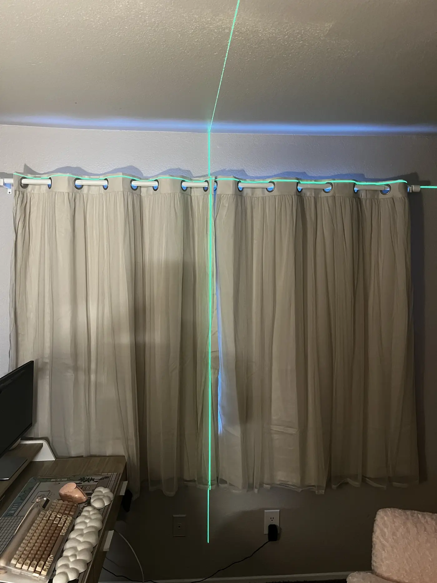 Grommet curtain panels hung on a white rod in a Sacramento home office, with the cross line laser lit along the rod