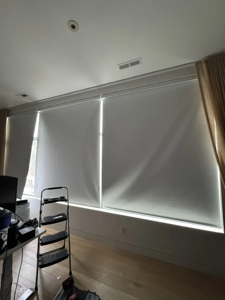 Roller shades fitted across a tall living room window in San Francisco, each panel set inside its own section of the frame