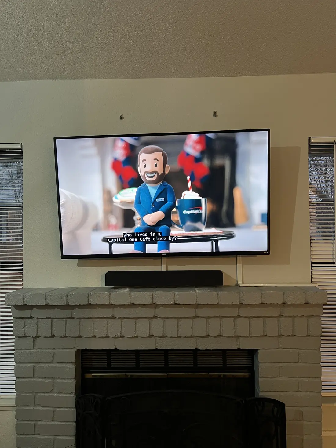 Flat screen mounted above a painted-brick fireplace in a Castro living room, with the soundbar set on the mantel below